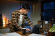 © Stella 16 - Focused man working late at night on laptop in kitchen with coffee