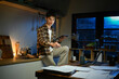 © Stella 16 - A man works late at night in a dimly lit kitchen.