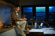 © Stella 16 - A man works late at night in a dimly lit kitchen.