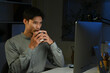 © Stella 16 - Businessman with cup of coffee working on computer in office at night
