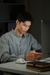 © Stella 16 - Shot of a young businessman using a laptop and smartphone during a late night in a modern office
