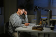 © Stella 16 - Staying late to get it done. Shot of a young businessman using a computer at his desk during a late night at work.
