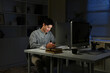 © Stella 16 - Shot of a young businessman using a laptop and smartphone during a late night in a modern office