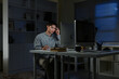 © Stella 16 - Businessman working overtime at his desk late at night
