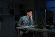 © Stella 16 - Staying late to get it done. Shot of a young businessman using a computer at his desk during a late night at work.