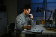 © Stella 16 - Businessman with cup of coffee working on computer in office at night
