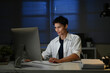 © Stella 16 - Staying late to get it done. Shot of a young businessman using a computer at his desk during a late night at work.