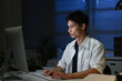 © Stella 16 - Staying late to get it done. Shot of a young businessman using a computer at his desk during a late night at work.