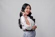 © Reezky - Cheerful young Asian woman in a white shirt pointing to the copy space behind her.