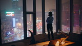 Confident ceo looking night city view from office panoramic window silhouette.