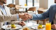 © Shah Zain - Two businessmen shaking hands at restaurant