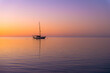 © Austockphoto - Tranquil yacht anchored at sea during a colourful sunset