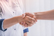 © InsideCreativeHouse - Healthcare and assistance concept. Close up of doctor and patient shaking hands. Support, aid, help and assistance of medical worker. Deal concept. Successful recuperation