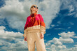 © VISTA by Westend61 - Trendy person in retro 1990s sportswear posing outdoors under blue sky