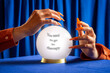 © VISTA by Westend61 - Hand with orange nails holding crystal ball with therapy message on blue velvet
