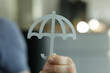 © vegefox.com - Image of a hand holding a paper umbrella, symbolizing protection, safety, and security. Ideal for insurance, finance, and risk management.