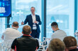 © Anton Gvozdikov - Business presentation taking place in professional setting with speaker addressing an audience of engaged attendees.