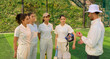 © Raushan_films - Indian asian young adult gen z woman lady group team standing coach man do sports discussion at match male guy trainer explain game strategy girls female player wear white uniform outdoor play ground