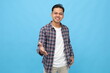 © ArvStd - Young Asian man smiling looking at camera, handshake gesture, concept of getting acquainted, introducing yourself or congratulating, standing isolated on blue background.