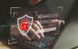 © iWissawa - Hacker hands typing on laptop with broken security shield, login interface and programming code. Cybercrime concept showing password cracking, credential theft and unauthorized system penetration.