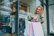 © Zamrznuti tonovi - Woman checking time while talking on phone after shopping spree