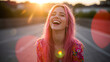 © Northlight Studio - A happy young woman with bright pink hair, laughing in a sunlit urban setting with a lens flare. This joyful and unique portrait captures a sense of freedom and individuality.