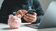 © Stock Studio - Online banking and savings concept with mobile phone piggy bank and laptop for financial growth