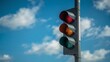 © viperagp - Traffic signal showing red light featuring yellow and green unlit, set against the bright blue sky with scattered clouds, captured within daylight from a low angle perspective