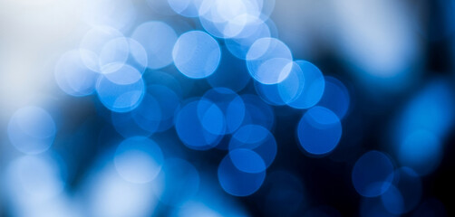 Abstract blurred blue and white bokeh lights on a dark background, giving a cool and mysterious feel that enhances elegant artistic visuals and modern creative compositions.