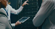 © peopleimages.com - Tablet screen, hand and discussion in server room for code or system performance. People, technology and technician group in data center for network diagnostics, software analytics and IT maintenance