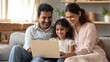 © Johannes - happy indian family couple with child daughter using laptop computer at home smiling parents and teen kid bonding watching streaming online tv or doing ecommerce shopping together sitting on sofa no