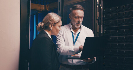 Laptop, teamwork and people with in server room for technical support, database or cybersecurity. Computer, collaboration and technicians with system upgrade in data center for network programming.