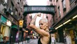 © ONE - A young woman with short hair and tattoos flexes her bicep in a city alleyway