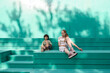 © Westend61 - Children friends sitting together on teal steps enjoying summer outdoors