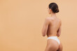 © anatoliycherkas - Back View of Young Asian Woman Showing Her Back on Beige Background