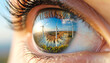 © ezra - Vision of Sustainable Future: A close-up view of an eye reflects a vibrant landscape of wind turbines under a sunny sky, symbolizing a commitment to the environment.