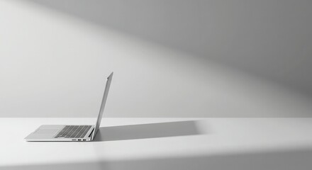 Silver laptop on a white surface, side view.
