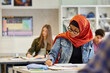 © Rido - Portrait of beautiful muslim student in hijab writing in classroom