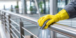 © xartproduction - Hand in yellow glove meticulously wiping a brushed stainless steel handrail