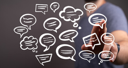 Stock photo of a man interacting with digital speech bubbles, illustrating communication, ideas, and social media.