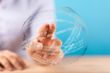 Close-up of a hand interacting with a digital sphere showing data and code.  Concept of technology and innovation.