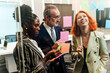 © artitwpd - Diverse team collaborates in modern office, brainstorming with sticky notes on glass wall. Startup workshop highlights strategy, planning, leadership, teamwork, and creative meeting energy.