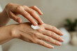 © Yuttana - Close up of hands applying moisturizing cream for skincare and wellness