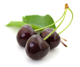 Dark red cherries with green leaves isolated on white background