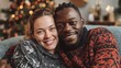 © Johannes - young happy couple embracing and relaxing on comfortable couch lovely multiethnic couple sitting on sofa wearing christmas sweater and hugging african woman and affectionate man near christmas tree n