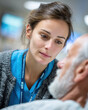 © kaleidoscope - Nurse attentively engages with elderly patient in a hospital room, offering support and comfort during treatment