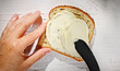 © Mara Zemgaliete - chef spreads fresh cream cheese on a slice of toast