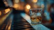 © HELENA - Whiskey glass on piano keys, bokeh background