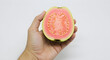© Ali - Closeup of Bited Guava in Hand on White Background