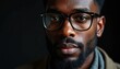 © Maryna - Close-up portrait of stylish man with eyeglasses, beard. Confident, serious expression, exuding professionalism, modern fashion sense. Man detailed facial features, sharp focus on eyes, glasses
